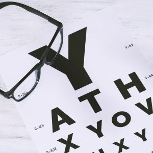 Spectacle frames on top of an Eye Chart at Jonathan Fransman Optometrists